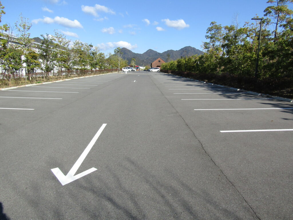 3.駐車場へ到着。写真は駐車場出口から撮影しています。中央の茶色のハウスそばが身障者優先駐車場。