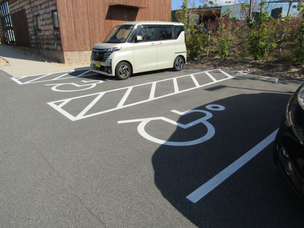 4.茶色ハウス(レセプションハウス)のそばに2台の身障者優先駐車場あり。無料駐車場（一般73台・大型バス2台）